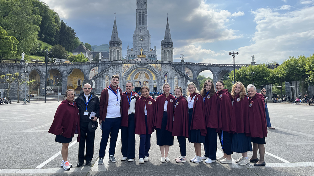 Students pose in front of a cathedral in Lourdes, France